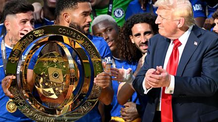 Chelseas Kapitän Reece James (l/vorn) hält auf dem Siegerpodest die Trophäe in den Händen und schaut irritiert zu US-Präsident Donald Trump.