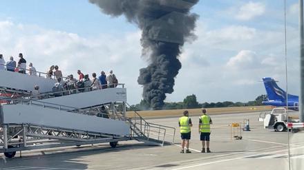 Nach dem Absturz eines Kleinflugzeugs steigt eine schwarze Rauchwolke aus einem Bereich in der Nähe der Landebahn auf.
