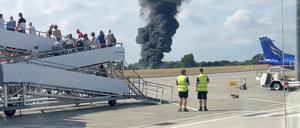 Nach dem Absturz eines Kleinflugzeugs steigt eine schwarze Rauchwolke aus einem Bereich in der Nähe der Landebahn auf.