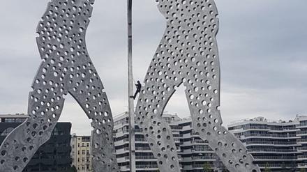 Polizisten kletterten auf die Skulptur „Molecule Man“, nachdem dort Aktivisten ein Banner angebracht hatten.
