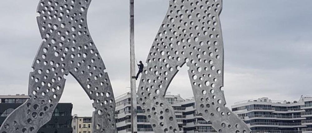 Polizisten kletterten auf die Skulptur „Molecule Man“, nachdem dort Aktivisten ein Banner angebracht hatten.