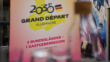 Das Logo für die Bewerbung zum geplanten Start der Tour de France 2030 in Ostdeutschland hängt auf einer Pressekonferenz.