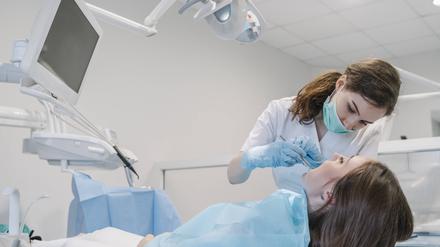 Eine junge Zahnärztin behandelt eine Patientin.