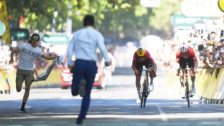 Während Jonas Abrahamsen und Mauro Schmid (r) in Toulouse um den Sieg sprinten, läuft ein Flitzer (l) auf die Zielgerade.