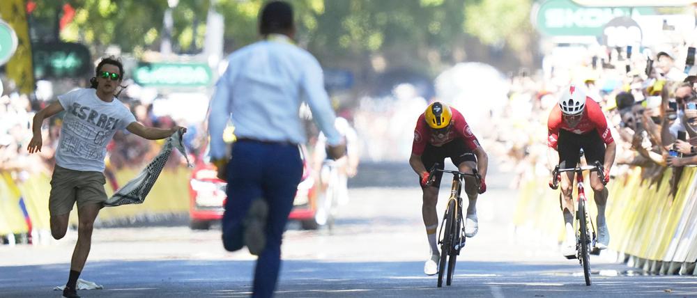 Während Jonas Abrahamsen und Mauro Schmid (r) in Toulouse um den Sieg sprinten, läuft ein Flitzer (l) auf die Zielgerade.