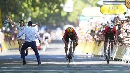 Ein Sicherheitsbeamter drängt in Toulouse einen Flitzer von der Zielgeraden, während Jonas Abrahamsen und Mauro Schmid um den Sieg sprinten.