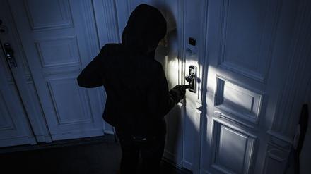 Gestellte Aufnahme: Ein Mann versucht eine Wohnungstür in einem Wohnhaus aufzubrechen. (Symbolbild)