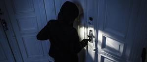 Gestellte Aufnahme: Ein Mann versucht eine Wohnungstür in einem Wohnhaus aufzubrechen. (Symbolbild)