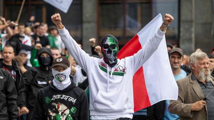 Fußball-Hooligans und andere Teilnehmer der von der rechtsextremen polnischen Partei  „Konfederacja“ organisierten Anti-Einwanderungs-Demonstration rufen am 19. Juli 2025 in der Warschauer Innenstadt Parolen in Richtung der Gegendemonstranten.