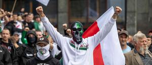 Fußball-Hooligans und andere Teilnehmer der von der rechtsextremen polnischen Partei  „Konfederacja“ organisierten Anti-Einwanderungs-Demonstration rufen am 19. Juli 2025 in der Warschauer Innenstadt Parolen in Richtung der Gegendemonstranten.