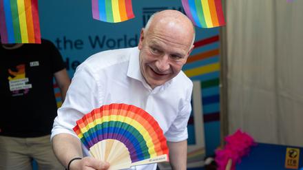 Kai Wegner (CDU), Regierender Bürgermeister von Berlin, hält beim lesbisch-schwulen Stadtfest einen Regenbogenfarbenen Fächer.