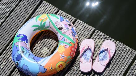 Ein Schwimmring und Badelatschen liegen auf einem Steg am Strandbad am Großen Müllroser See.  