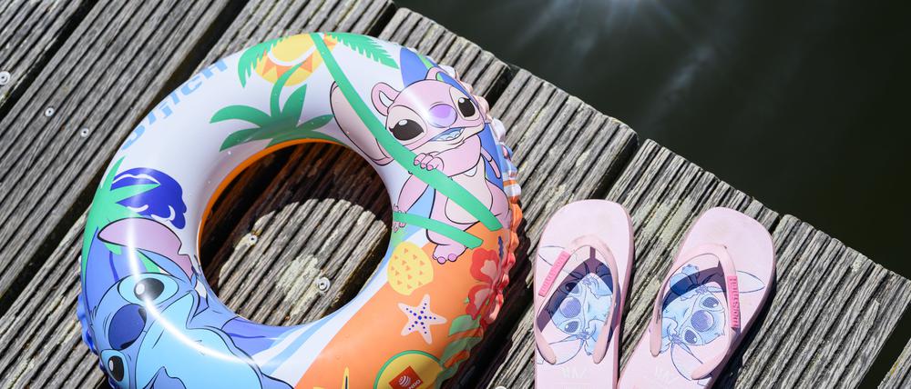 Ein Schwimmring und Badelatschen liegen auf einem Steg am Strandbad am Großen Müllroser See.  