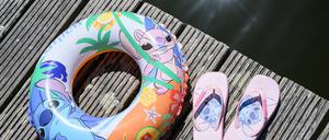 Ein Schwimmring und Badelatschen liegen auf einem Steg am Strandbad am Großen Müllroser See.  