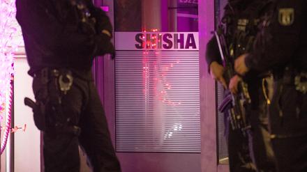 Beamte von Polizei und Zoll führen in einer Shisha-Bar eine Polizeikontrolle durch.