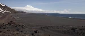 Schwarzer Sandstrand und der schneebedeckte Vulkan Beerenberg: Viel mehr gibt es auf der Insel Jan Mayen eigentlich nicht.