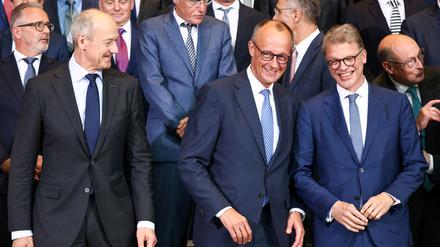 Bundeskanzler Friedrich Merz (Mitte) mit den CEOs von Siemens und Deutscher Bank, Roland Busch (links) und Christian Sewing (rechts).