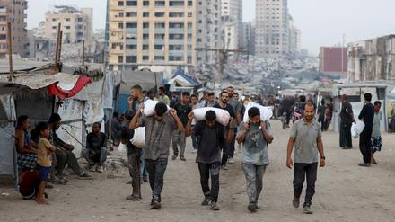 Palästinenser mit Hilfsgütern im zerstörten Gaza-Stadt.