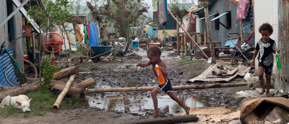 Kinder spielen auf einer Straße auf einer Insel von Vanuatu, nachdem ein Zyklon ihr Dorf verwüstet hat.