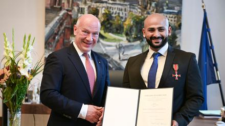Kai Wegner hat Yousef Ayoub das Bundesverdienstkreuz samt Urkunde überreicht. 