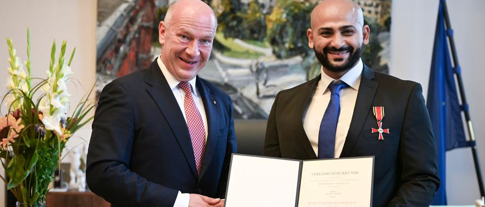 Kai Wegner hat Yousef Ayoub das Bundesverdienstkreuz samt Urkunde überreicht.