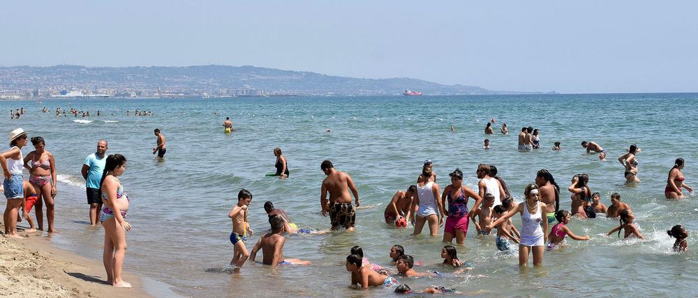 Badende Menschen in Sizilien. 