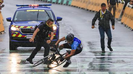 Ein Mann fährt bei der Tour de France unerlaubt über die Strecke. 