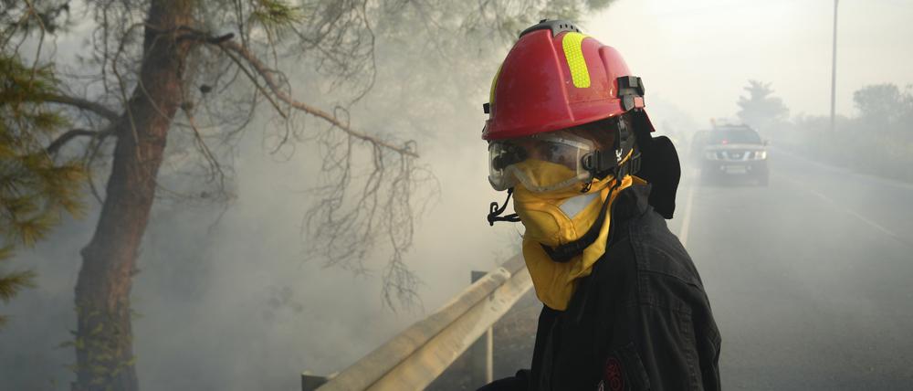 Eine Feuerwehrfrau und ihre Kollegen versuchen ein Feuer im Dorf Souni auf Zypern zu löschen.