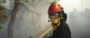 Eine Feuerwehrfrau und ihre Kollegen versuchen ein Feuer im Dorf Souni auf Zypern zu löschen.