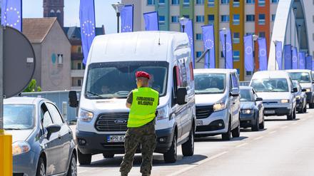 Ein polnischer Militärpolizist steht am Grenzübergang Stadtbrücke zwischen Frankfurt (Oder) in Brandenburg und dem polnischen Slubice. Pendler und Reisende stehen mit ihren Autos im Stau vor der polnischen Grenzkontrolle.