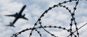 Ein Flugzeug hebt am Flughafen BER hinter einem Zaun mit Natodraht ab. +++ dpa-Bildfunk +++