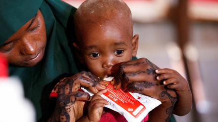 Die Somalierin Adar Hassan Abdulahi hilft ihrem Kind nach einer Impfung.