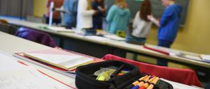 Schüler stehen während des Deutschunterrichts vor der Tafel und unterhalten sich über ihre Aufgabe. 