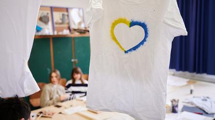 Ein T-Shirt mit einem Herz, umrahmt von den ukrainischen Farben hängt im Klassenraum einer Willkommensklasse am Willy-Graf-Gymnasium in Berlin-Lichterfelde. 