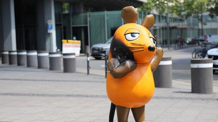 Mit einem großen Brandfleck steht die Maus vor dem WDR-Gebäude. 