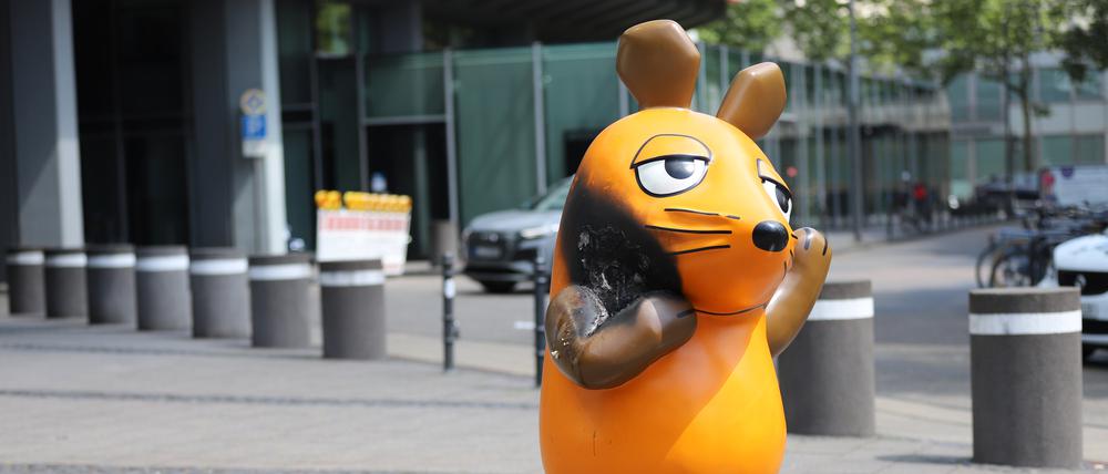 Mit einem großen Brandfleck steht die Maus vor dem WDR-Gebäude.