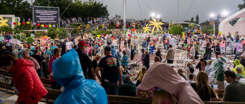 Zuschauer verlassen die ZDF-“Fernsehgarten“-Arena nach wetterbedigtem Abbruch.