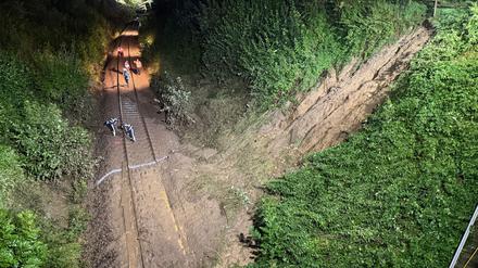 Einsatzkräfte arbeiten an den Gleisen nahe eines Erdrutsches. Bei dem Zugunglück im Südosten Baden-Württembergs sind drei Menschen ums Leben gekommen.
