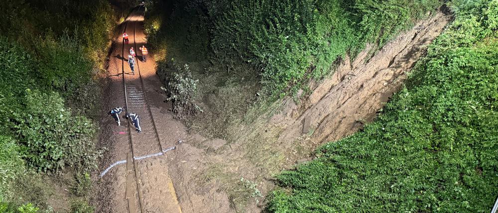 Einsatzkräfte arbeiten an den Gleisen nahe eines Erdrutsches. Bei dem Zugunglück im Südosten Baden-Württembergs sind drei Menschen ums Leben gekommen.