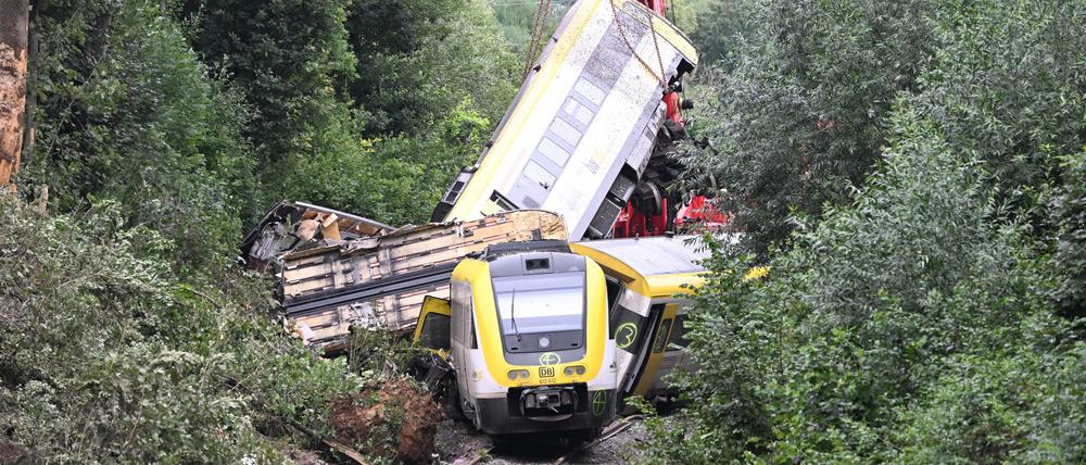 Mit einem Kran wird an der Unfallstelle bei Riedlingen, an der ein Regionalzug entgleist ist, ein Waggon angehoben.