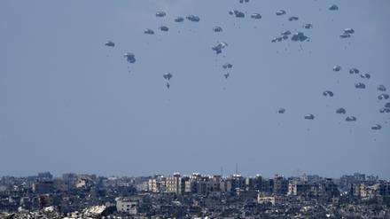 Abgeworfene humanitäre Hilfslieferungen sinken an Fallschirmen in den nördlichen Gazastreifen. 