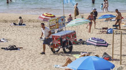 Ein Strandverkäufer verkauft Eis am Strand. Der beliebte französische Badeort Les Sables- d’Olonne ermahnt Strandgäste neuerdings zu angemessener Kleidung auf seinen Straßen. 