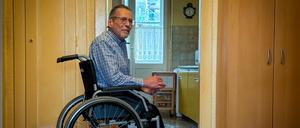 Michael Starke im Rollstuhl in der Diele seiner Mietwohnung, er trägt spezielle orthopädische Schuhe. 