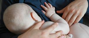 Eine Mutter stillt ihr Baby zu Hause. 