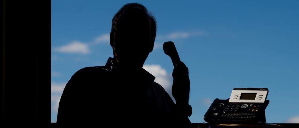 Ein Mann hält ein Telefon (Symbolfoto).