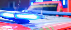 Blaulichter leuchten an einer Einsatzstelle auf einem Notarzt Fahrzeug und einem Rettungswagen.