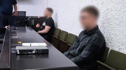 Ein in Haft sitzender (l) und ein nicht in Haft sitzender Angeklagter sitzen im Prozess um Bombendrohungen im Südwesten in einem Saal des Landgerichts Stuttgart.