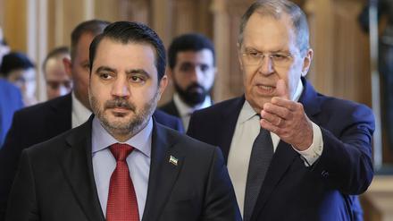 Der russische Außenminister Sergej Lawrow, rechts, und der syrische Außenminister Asaad al-Schaibani (l) betreten während ihres Treffens einen Saal. 