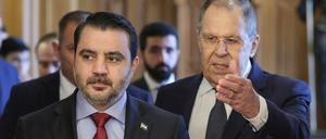 Der russische Außenminister Sergej Lawrow, rechts, und der syrische Außenminister Asaad al-Schaibani (l) betreten während ihres Treffens einen Saal. 