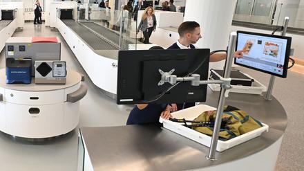 ARCHIV - 24.05.2023, Bayern, München: Zwei Mitarbeiter der Sicherheitskontrolle überprüfen in einer von insgesamt fünf neuen Anlagen am Flughafen München Gepäckstücke. Die neuen Scanner machen die Kontrolle mit moderner "3D-Technik" sicherer und schneller und für die Fluggäste deutlich bequemer. (zu dpa: «EU ebnet Weg für mehr Flüssigkeit im Flugzeug-Handgepäck») Foto: Angelika Warmuth/dpa +++ dpa-Bildfunk +++